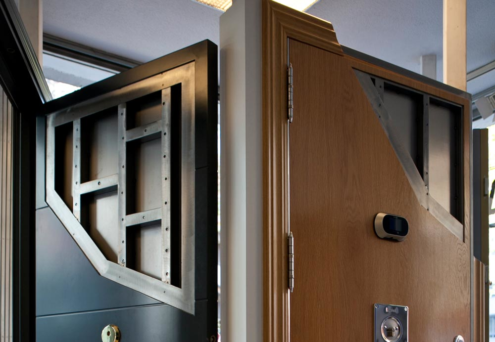 Puertas antibalas con estructura interna de acero reforzado y revestimiento exterior de madera natural.